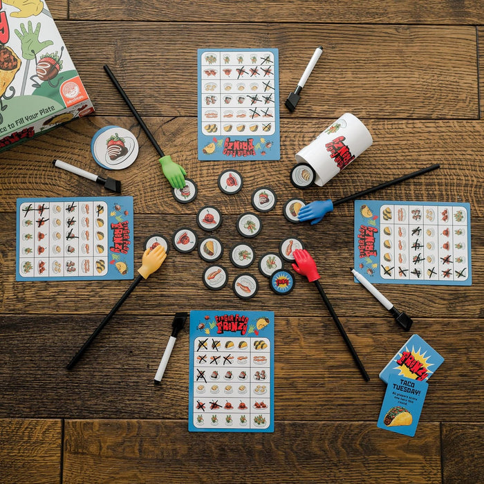 Board game with colorful hand-tipped sticks, food tokens, and dry-erase scorecards on a wooden surface.