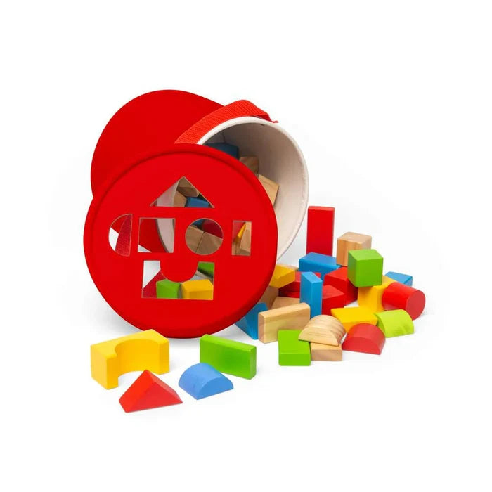 Colorful wooden blocks in various shapes spilling from a red bucket with a shape-sorter lid.