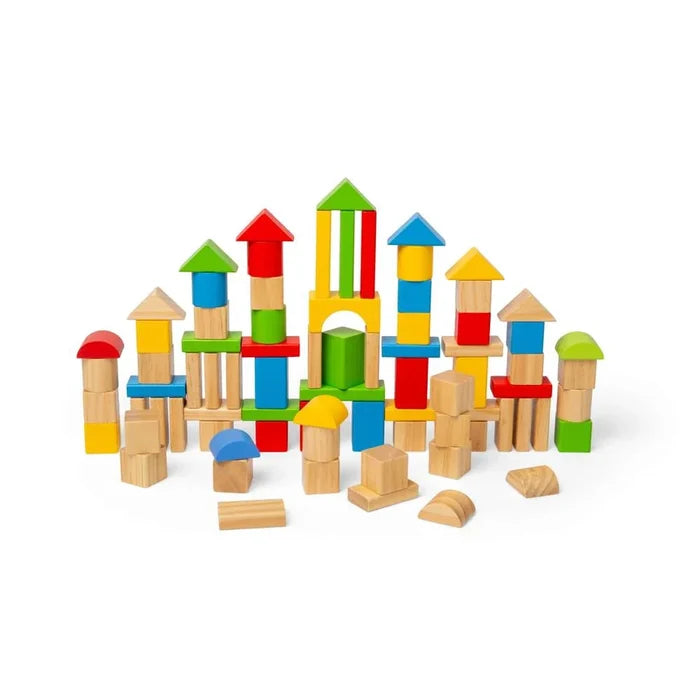 Assorted red, blue, yellow, and green wooden blocks in geometric shapes stacked like a castle on a white background.