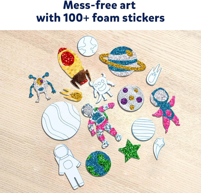 Colorful space-themed foam stickers with glittery foil patterns of planets, astronauts, and rockets on a wood surface.
