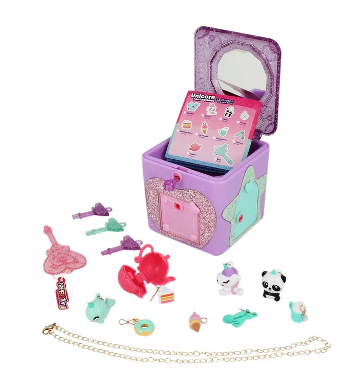 Open purple glittery jewellery box with mirror, collector guide, tiny colourful charms, keys, and a gold chain.