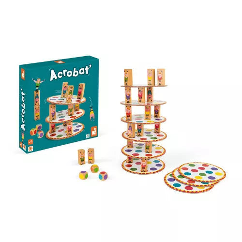 Teal box next to a balancing tower of white discs with colored dots, small wooden figures, and three wooden dice.