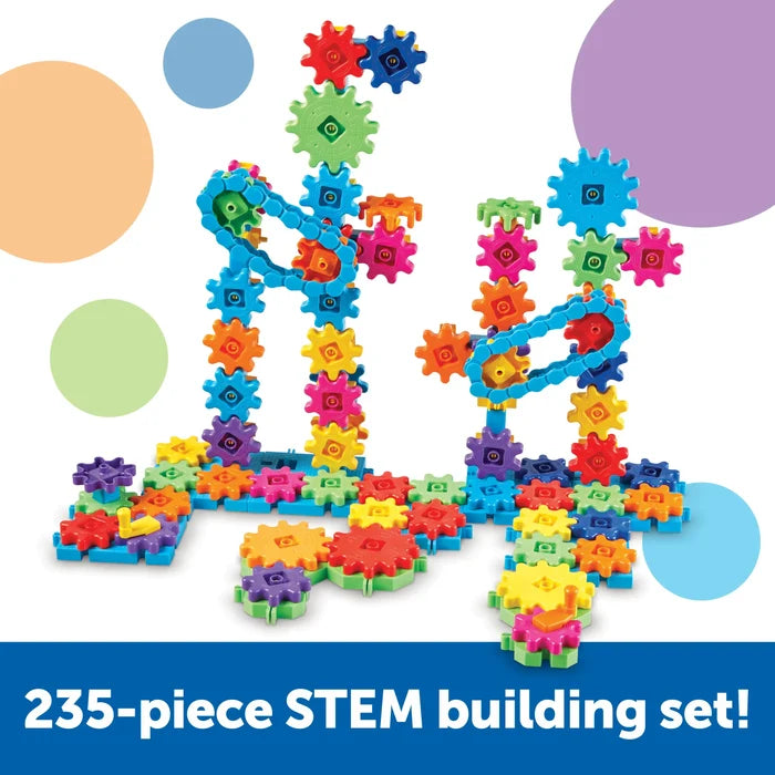 Vertical towers of colorful plastic gears and blue chains on interlocking bases. Text: 235-piece STEM building set.
