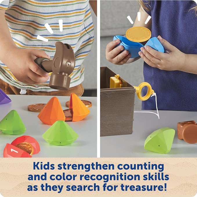 Children use a toy hammer to crack open colorful plastic gems revealing gold coins near a toy treasure chest.