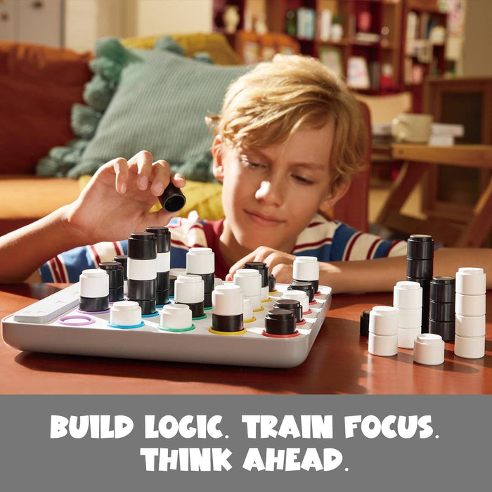 Boy playing a 3D board game with stacking black and white pieces on an electronic base with colorful light rings.