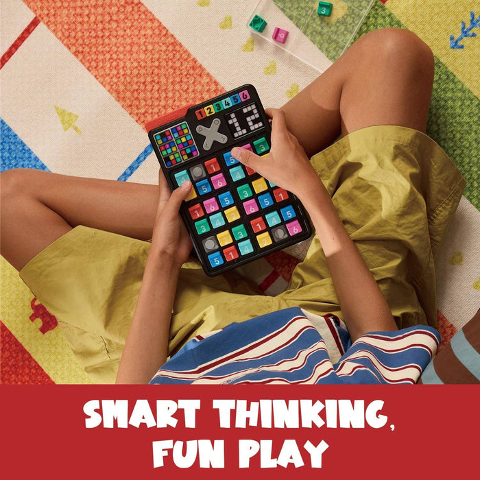 Handheld electronic game with a 6x6 grid of colorful numbered buttons held by a person on a patterned rug.