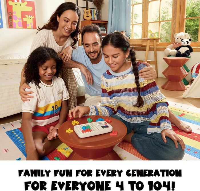 Smiling family playing with a white handheld electronic puzzle and colorful plastic blocks on a small round table.