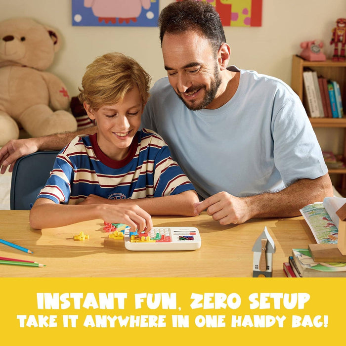 A father and son play with a white handheld electronic puzzle featuring colorful block patterns on a wooden table.