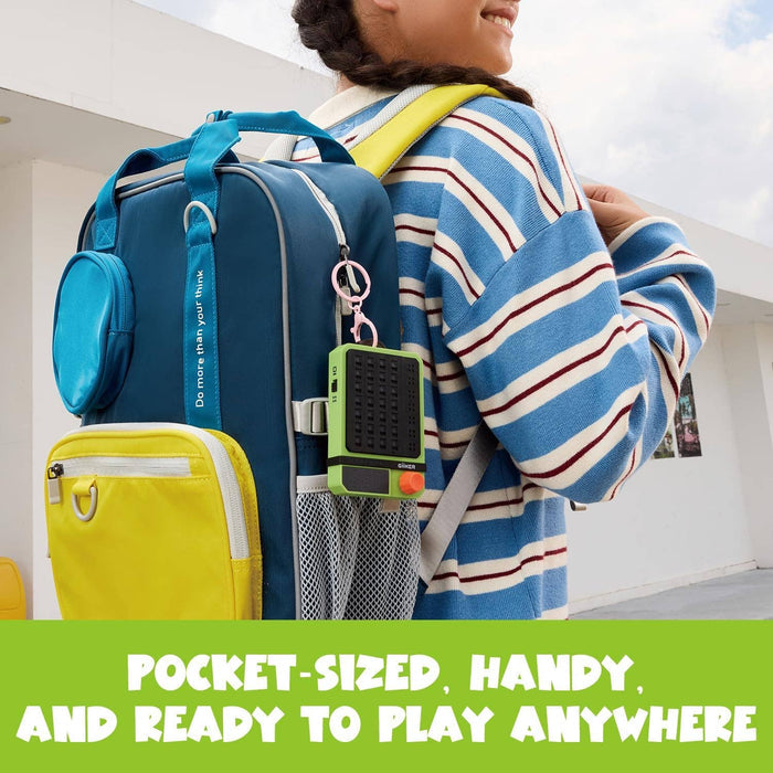 Green handheld electronic game with an orange dial clipped to a blue backpack with a pink keychain.