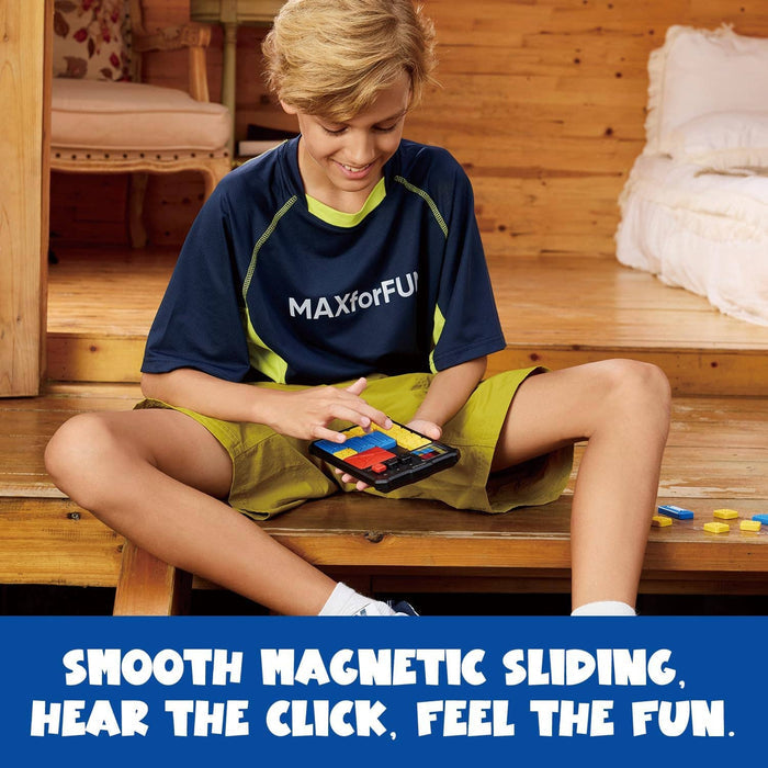 A boy sits on wooden steps playing a handheld puzzle game with sliding blue, red, and yellow magnetic tiles.