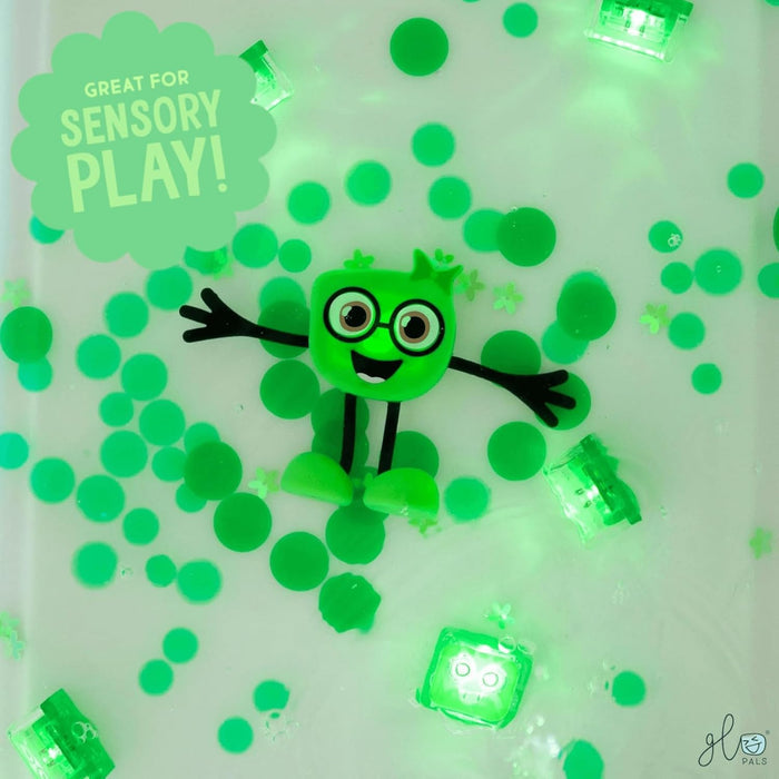Green square character with glasses floats in water with green water beads and glowing green cubes.
