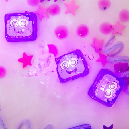 Three glowing purple cubes with cartoon faces float in water with pink stars and a vibrant purple glow.