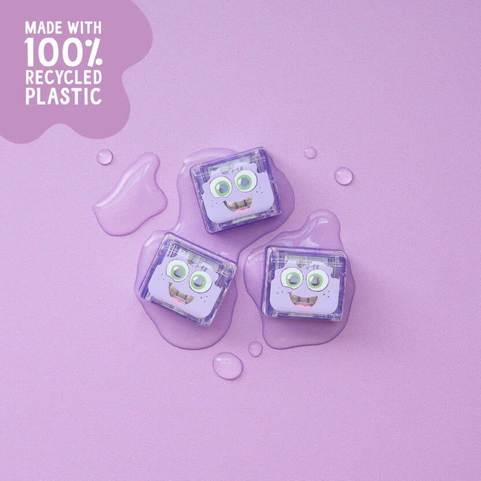 Three purple light-up cubes with smiling faces sitting in clear liquid pools on a light purple background.
