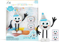 White square toy with a party hat and spindly black limbs, shown with two light-up cubes and its retail packaging.