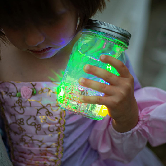 Child holding a glass jar filled with glowing green and yellow cubes that illuminate their pink princess dress.