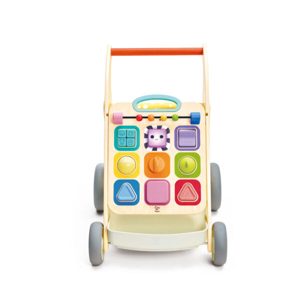 Wooden baby walker with orange handle and a colorful activity panel featuring shapes, gears, and spinning elements.