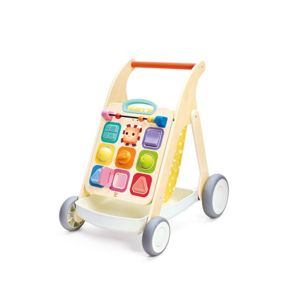 Wooden push walker with a colorful activity panel, orange handle, and white storage tray on four grey wheels.