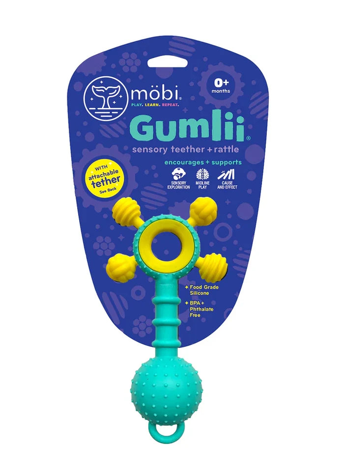 Teal and yellow silicone sensory teether rattle with a textured ball and ring on purple retail packaging.