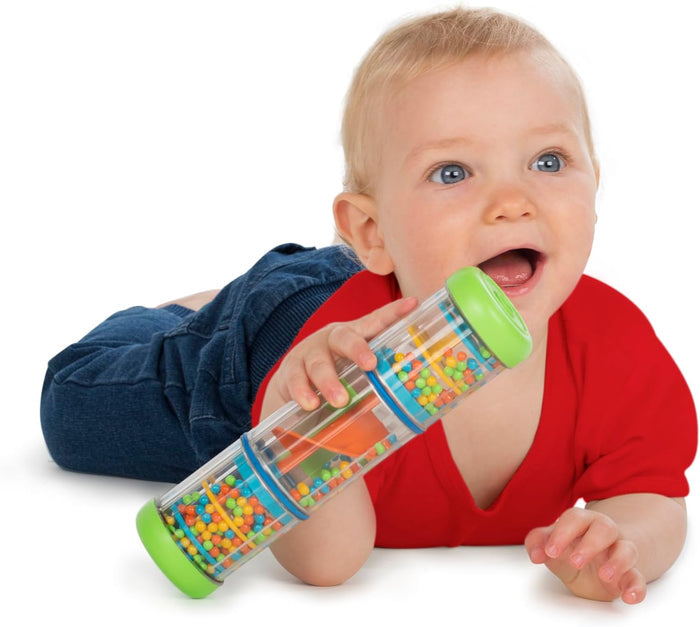 Baby holding a clear cylindrical rattle with green ends and colorful spinning beads inside.