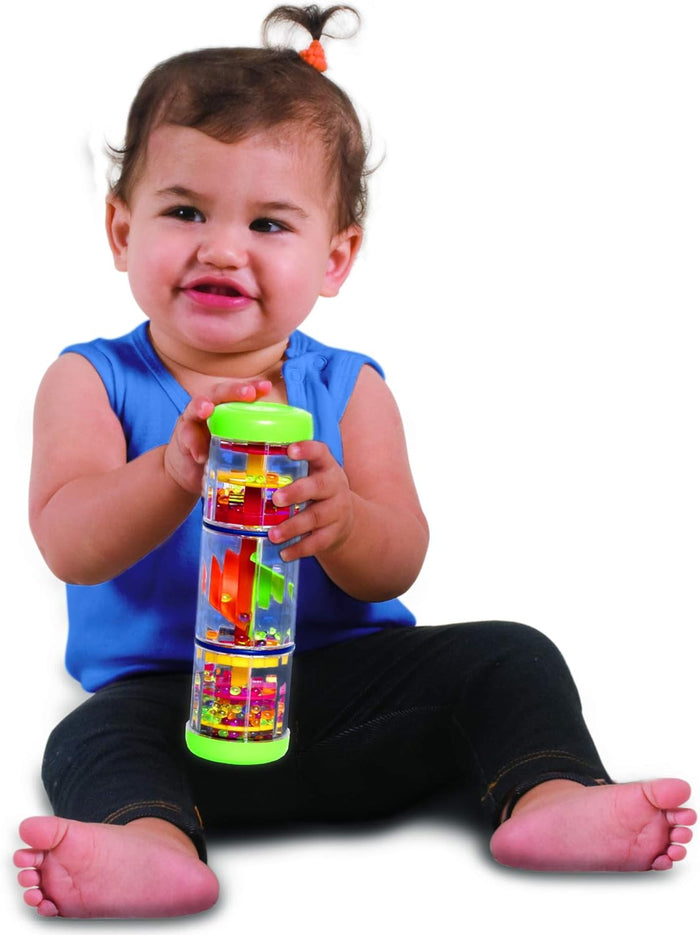 Smiling baby holding a clear cylinder toy with green caps, colorful internal spinning parts, and beads.