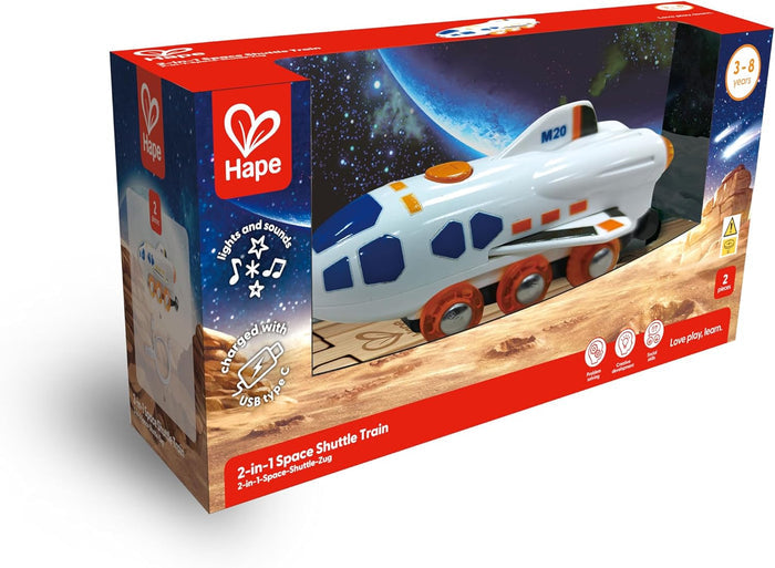 White toy space shuttle train with orange wheels in red Hape packaging featuring space graphics and USB-C icon.