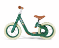 Forest green balance bike with brown seat and grips, cream tires, and colorful decals on a low-step frame.