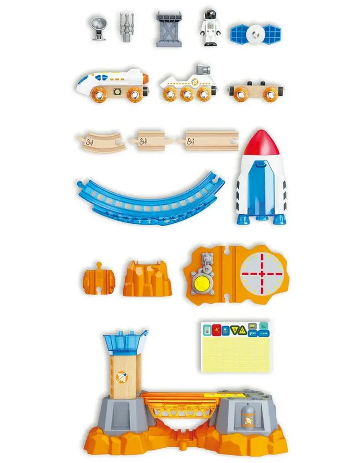 Space toy set featuring a rocket, astronaut, rover, and control tower with wooden tracks on a white background.