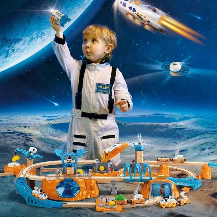 Child in astronaut suit playing with orange and blue space-themed wooden train tracks on a lunar landscape.