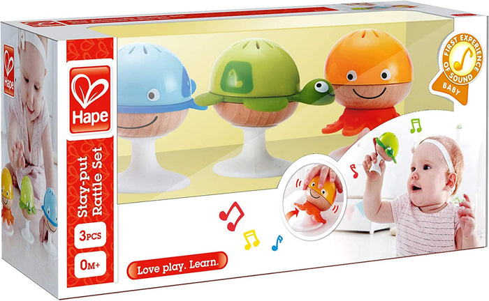 Blue whale, green turtle, and orange octopus suction rattles with smiling wooden faces in a white retail box.