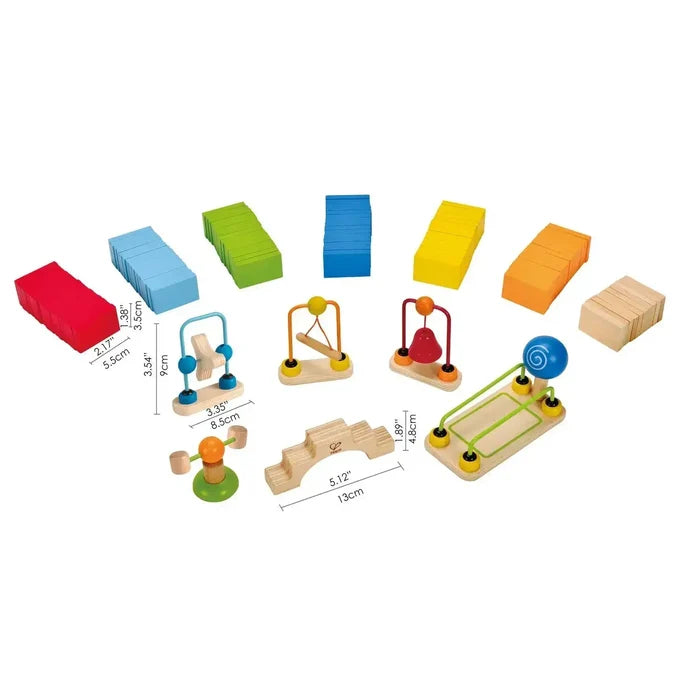 Stacks of colorful wooden dominoes and interactive accessories including a bridge, bell, swing, and ball ramp.