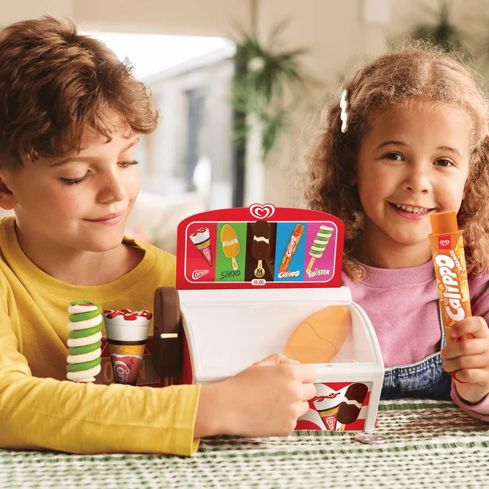 Two kids play with a red and white toy freezer featuring miniature Cornetto, Magnum, and Calippo ice cream treats.