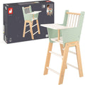 Mint green and white wooden doll high chair standing next to its dark grey Janod packaging showing a child playing.