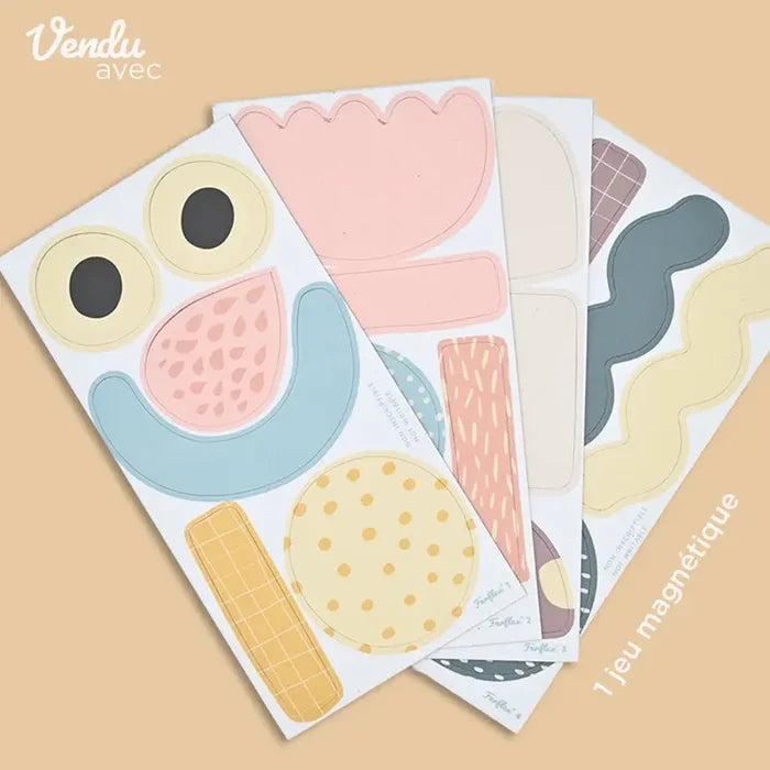 Four sheets of colorful magnetic shapes including eyes, smiles, and patterns in pastel pink, blue, and yellow.