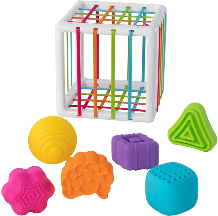 White cube toy with colorful elastic bands and six textured sensory blocks in different colors and shapes.