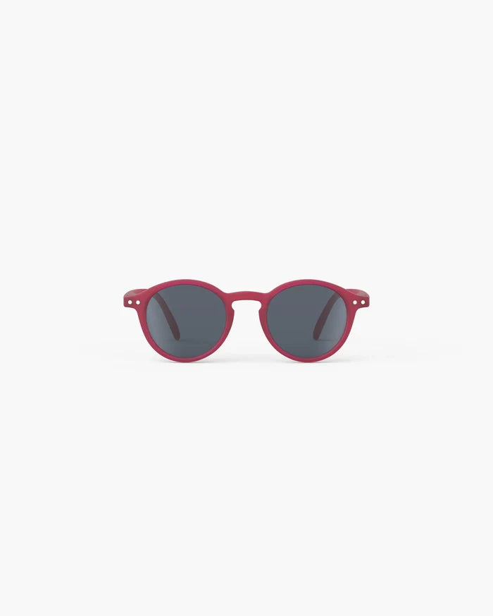 Round magenta kids' sunglasses with grey lenses and silver hinge details on a plain white background.