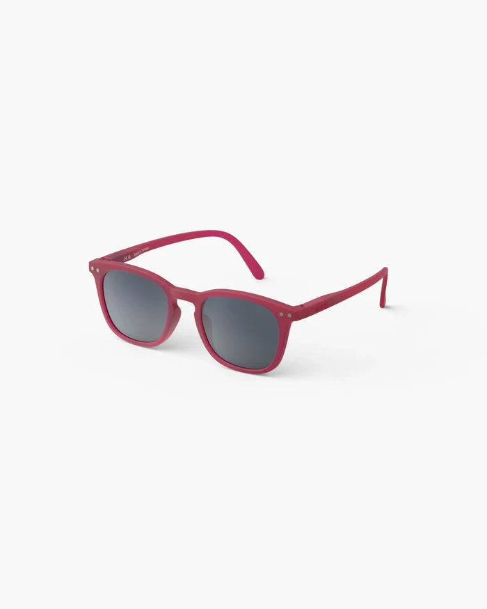 Magenta matte kids' sunglasses with rounded square frames, dark grey lenses, and silver hinge details.