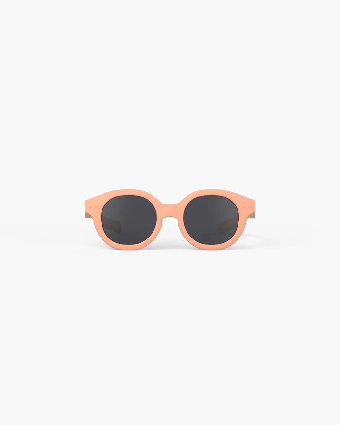 Round peach-colored kids' sunglasses with chunky frames and dark circular lenses, shown from the front on a white background.