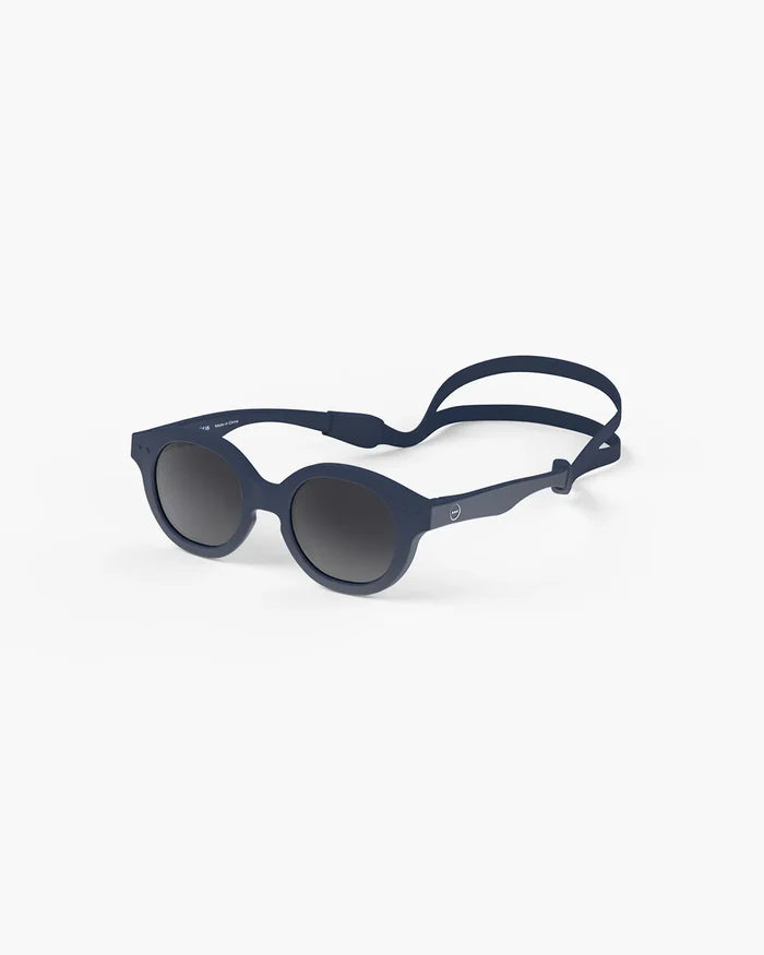 Navy blue round sunglasses for toddlers with dark grey lenses and a matching adjustable silicone head strap.