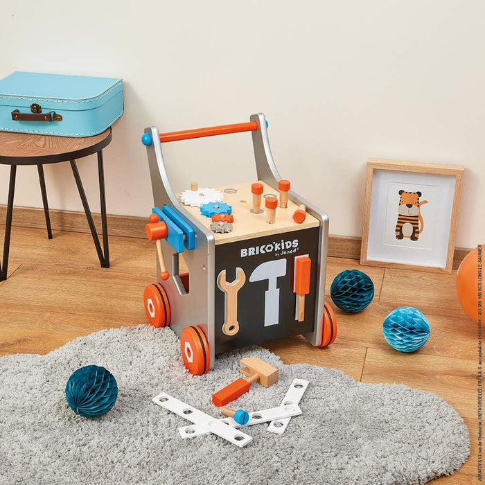 Grey and orange wooden walker with magnetic toy tools, gears, and workbench top on a grey rug.