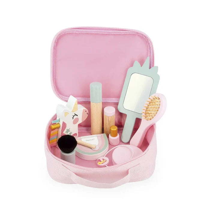 Open pink fabric vanity case filled with wooden toy makeup including a unicorn mirror, hairbrush, and lipstick.