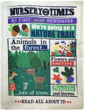 Front view of a cloth baby toy styled like a newspaper with 'Nursery Times' text and nature-themed illustrations.