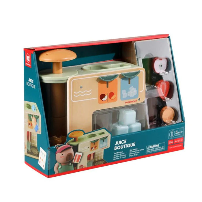 Wooden toy juice bar set in a blue box with a manual plunger, toy fruit slices, and light blue ice cube accessories.