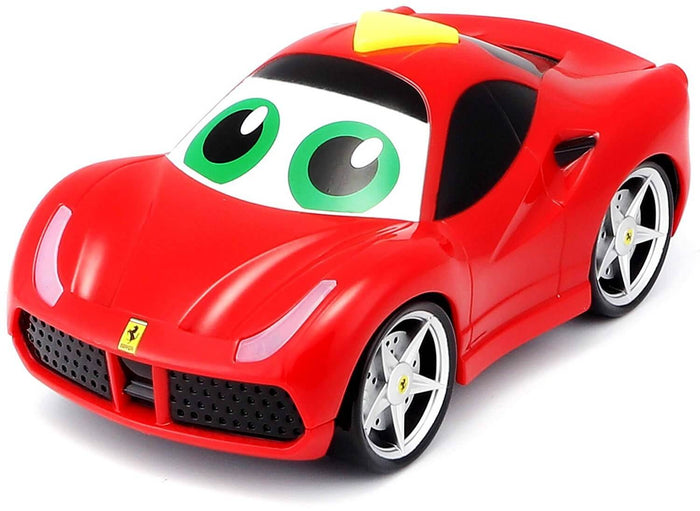 Bright red toy car with large green cartoon eyes on the windshield, silver rims, and a yellow button on top.