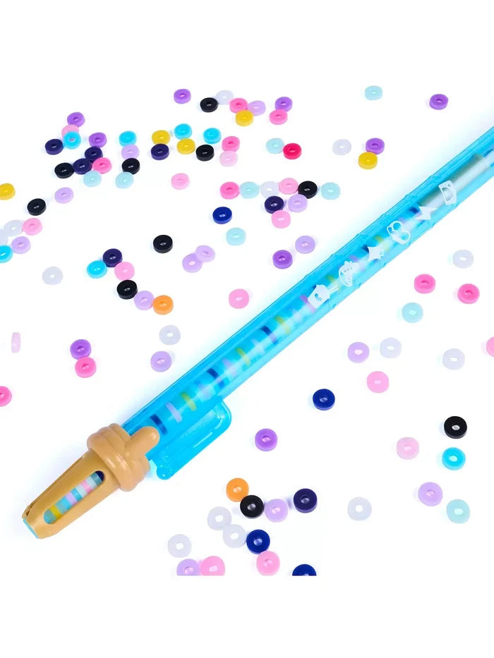Translucent blue bracelet tool with a tan tip and colorful flat disc beads scattered on white.