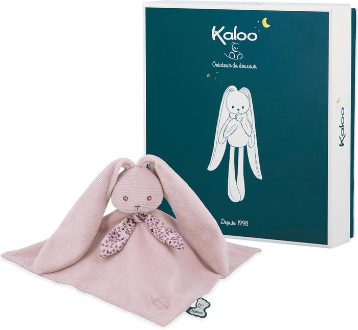 Pale pink plush rabbit comforter with long floppy ears and a floral bow, next to its teal Kaloo gift box.