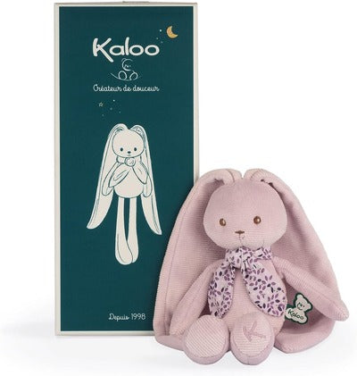 Plush pink bunny with long floppy ears and a purple floral scarf next to its dark green and gold gift box.