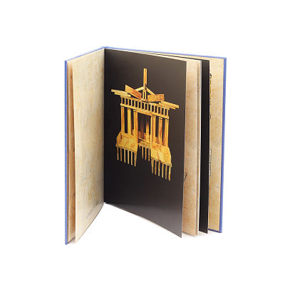 Open blue hardcover book featuring a photo of a wooden block temple structure on a black page.