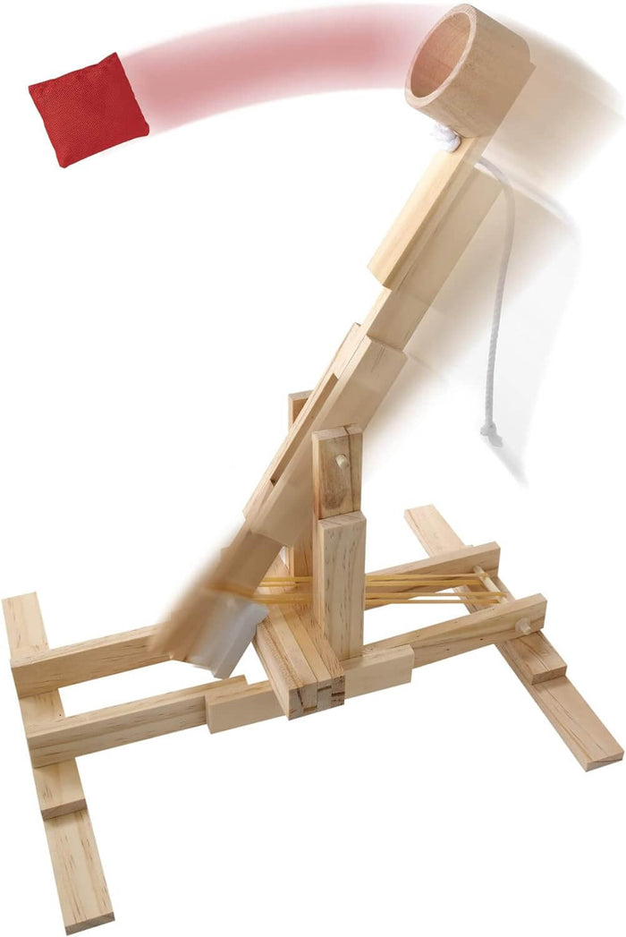 Wooden catapult launching a red beanbag with motion blur, featuring rubber bands and light-colored wood construction.