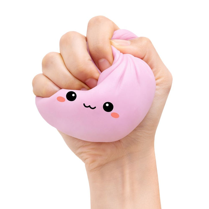 Hand squeezing a soft pink dumpling squishy toy with a cute smiling face and pink cheeks.