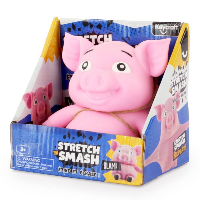 Pink rubber pig toy with a smiling face inside its blue and yellow Stretch N Smash retail display box.